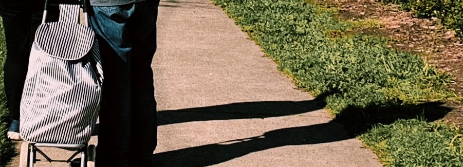 Man and woman with shoppping bag and shadow on ground