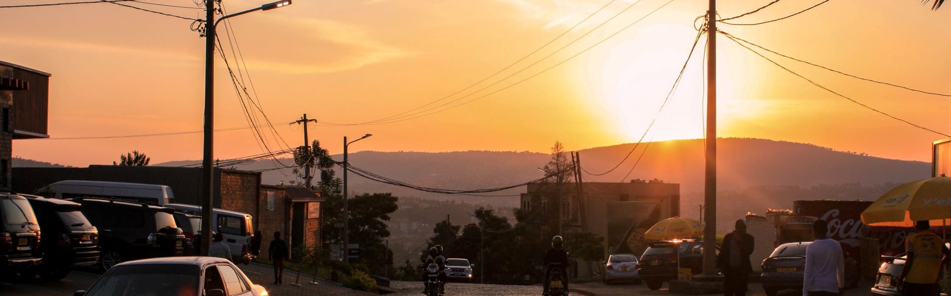 sunset over mountain ana town with cars and people